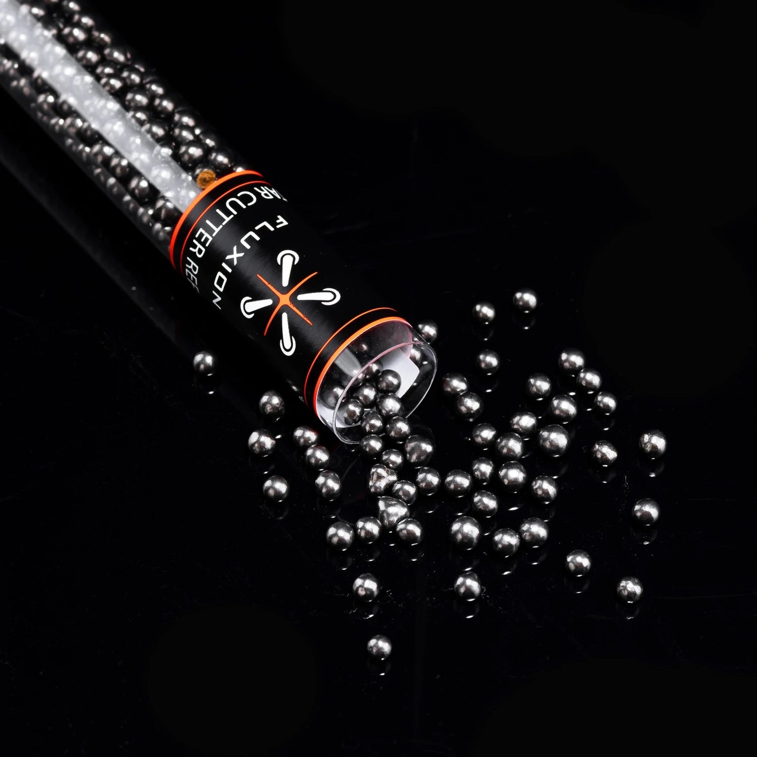 Flux Tar Cutter carbon bead refill tipped over on black surface with beads spilling in scattered pile