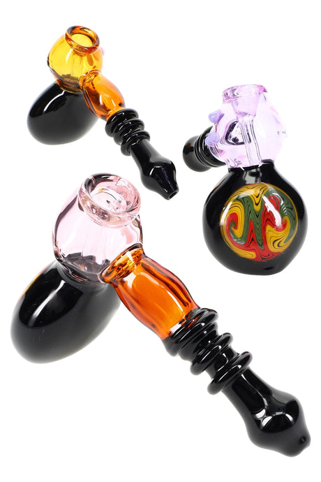 7-inch reverse rasta glass hammer bubbler with ringed black mouthpiece and compact water chamber; multicolored accents; sold individually.