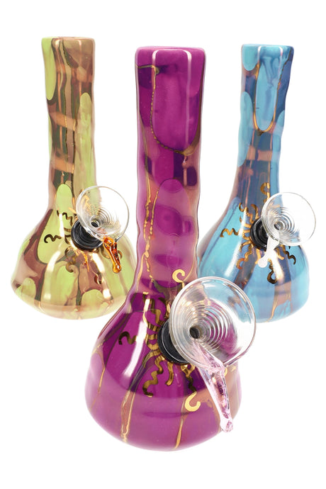 Group of US-made 6″ ceramic beaker bongs with marbled colors and gold sunburst detailing on the beaker base.