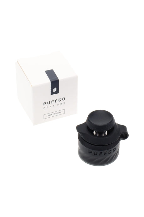 Black Puffco Peak Pro Joystick Cap next to packaging, easy-grip silicone Peak Pro accessory with joystick airflow for concentrates.