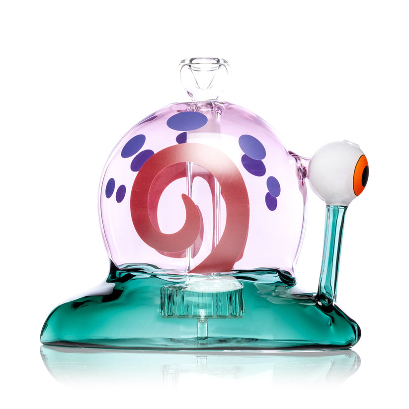 Profile shot of teal-base Snail XL glass bong with pink dome shell, purple spots and raised eyeball stem, isolated on white for product display.