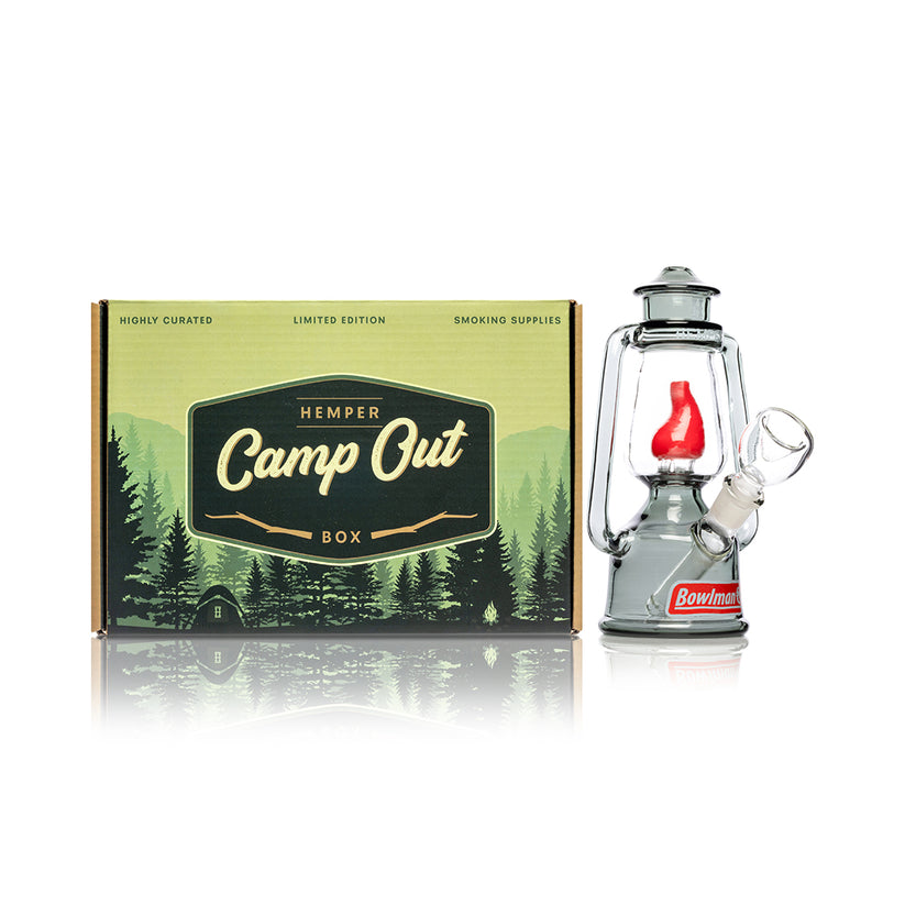 Hemper Bowlman Lantern mini bong posed next to Camp Out gift box, showing smoke glass body, lantern handles and tilted clear bowl.