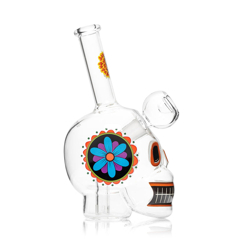 Side profile of Hemper Dia De Los Muertos skull glass bong highlighting blue and purple flower mandala decal and compact clear base.