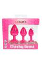 Cheeky Gems three-piece silicone butt plug set in bright pink with flared jewel bases, presented in retail box with waterproof icons.