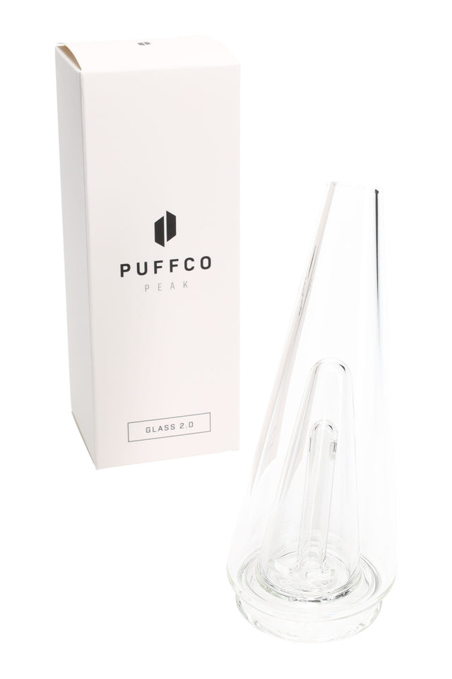 Clear Puffco Peak Glass 2.0 replacement top shown beside retail box, tapered cone body with internal downstem for water filtration.