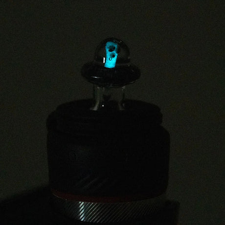 Low-light shot of the Martian cap on a Puffco Peak Pro showing a faint blue glow inside the clear dome.