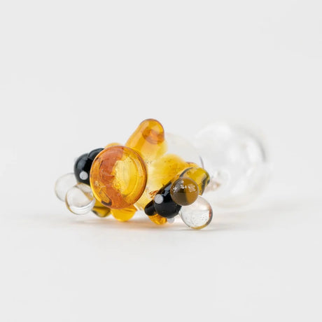 Close-up of the beehive topper highlighting striped bee details and sculpted honeycomb forms attached to a clear base.