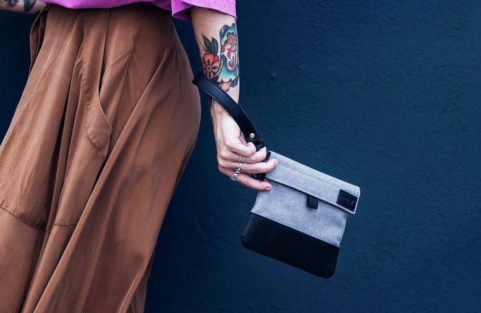 GRAV smell-proof pouch carried by wrist strap with gray fabric, black base, and compact streetwear styling