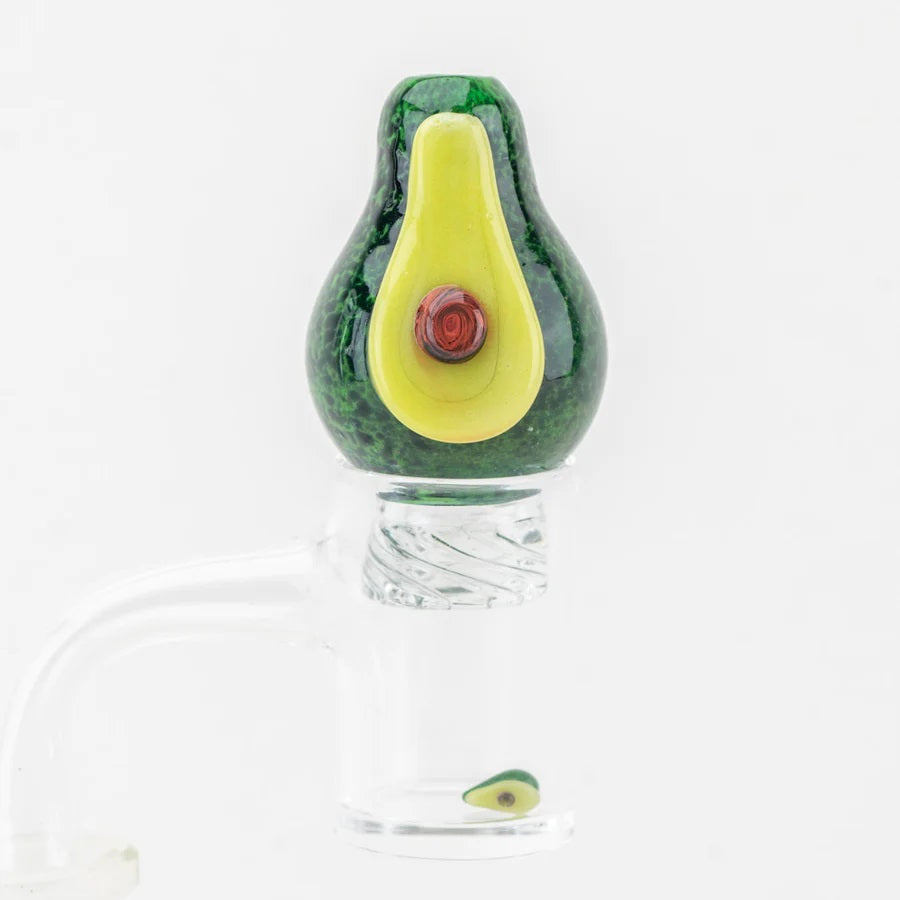 Avocado spinner cap seated on a flat-top quartz banger with matching mini avocado pearl spinning inside the bucket.