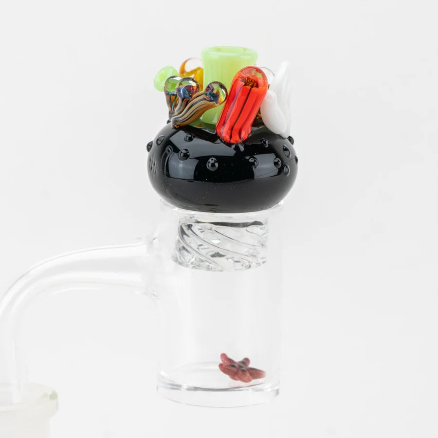 Cap seated on a quartz banger with the red starfish pearl inside the bucket, demonstrating real-world use.