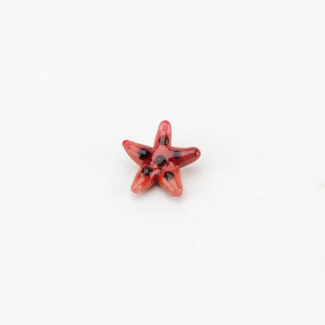 Small red starfish terp pearl with black spots, sized to spin inside a heated quartz banger for better vapor.