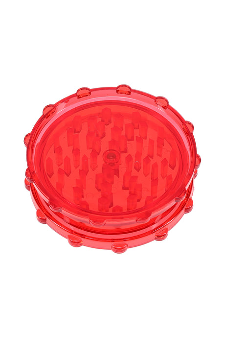 Red acrylic 2-piece magnetic herb grinder with raised peg teeth and knurled rim for easy twist.
