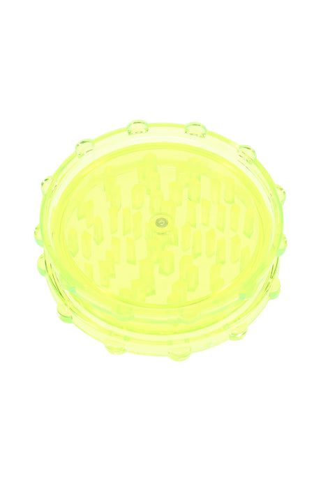 Neon yellow acrylic magnetic 2-piece grinder showing clear chamber and uniform peg teeth.