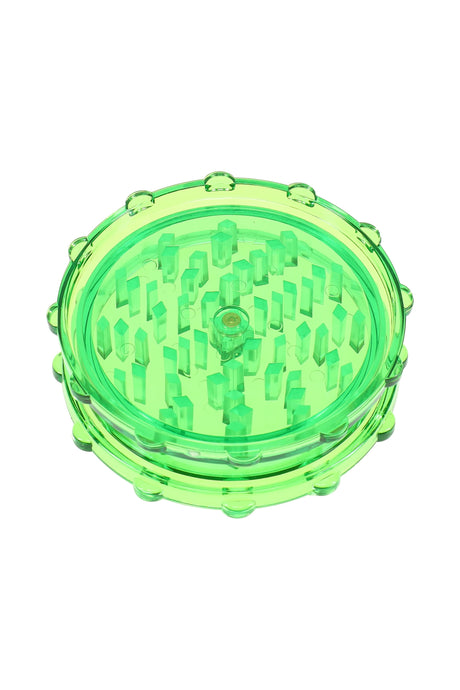 Green acrylic magnetic herb grinder with translucent body and evenly spaced grinding pegs.