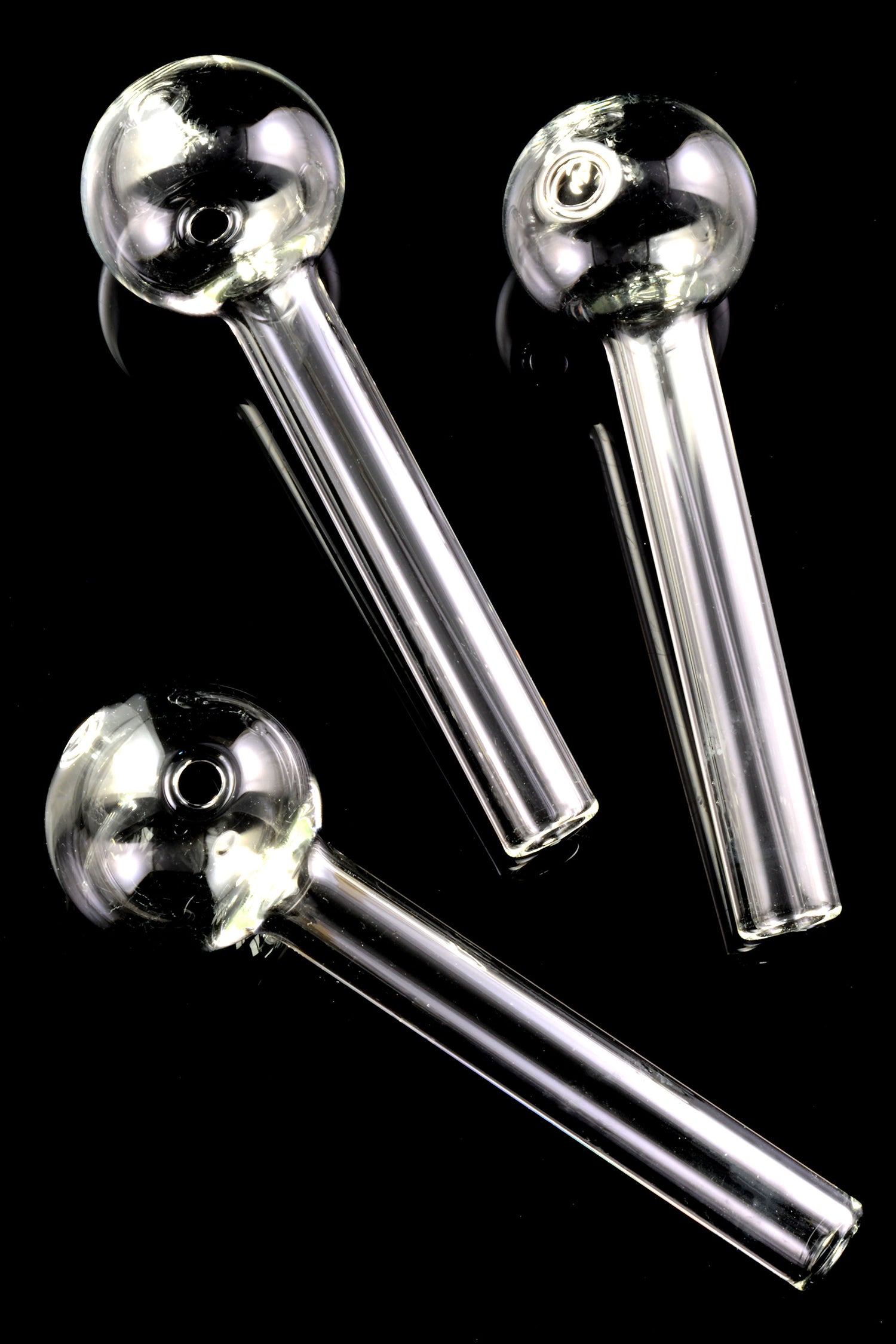 Three clear thick glass oil burner pipes on a black backdrop, each with globe head and straight stem; US-made and sold individually.