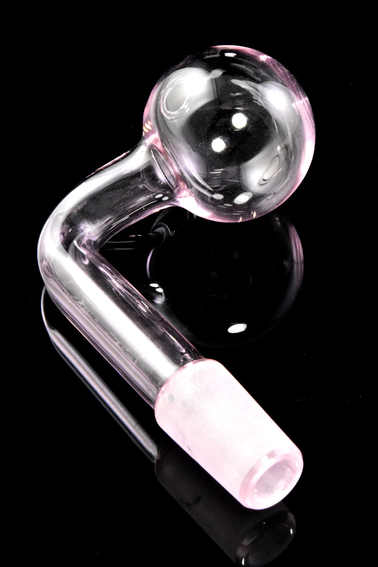 Pink L-shaped 14.5 mm male glass oil burner featuring clear globe head and frosted joint; reflective black backdrop.