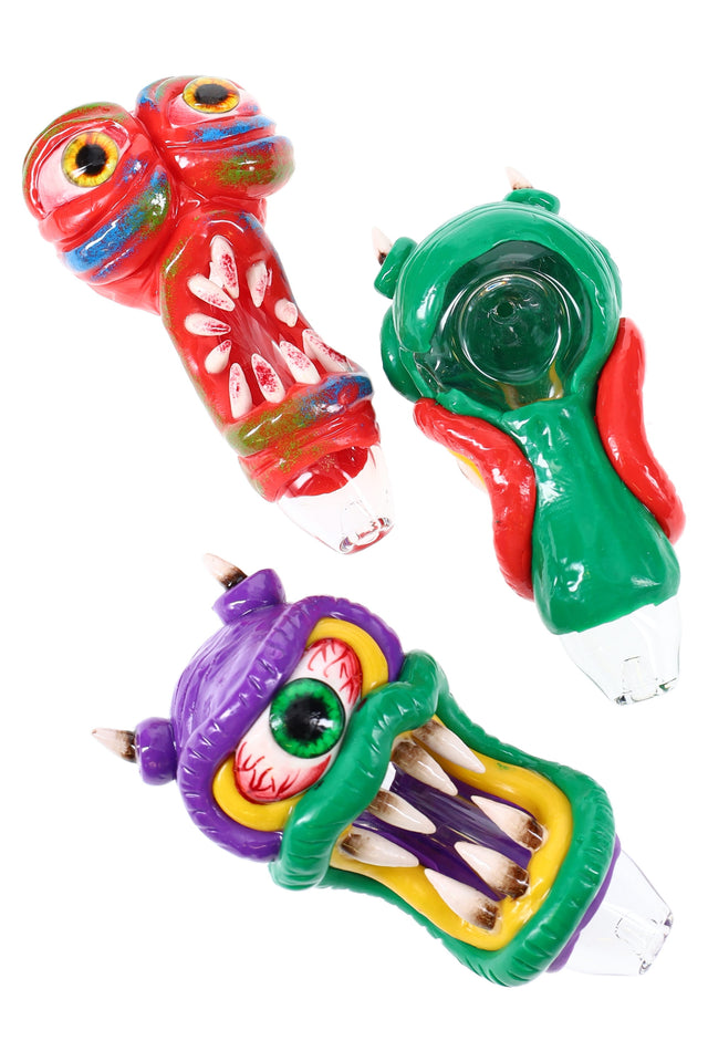 4½″ monster glass spoon pipe with sculpted resin fangs and eyeballs on a clear body; assorted colors, about 110 g, sold individually.