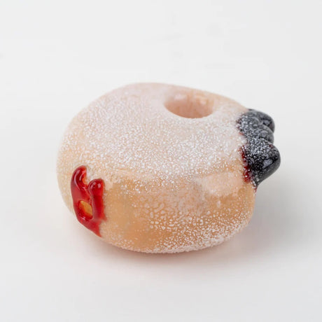 Angled view highlighting frosted exterior and side jelly accent on the donut glass hand pipe.