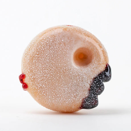 Close view of the jelly-filled bite detail on a frosted glass donut dry pipe.
