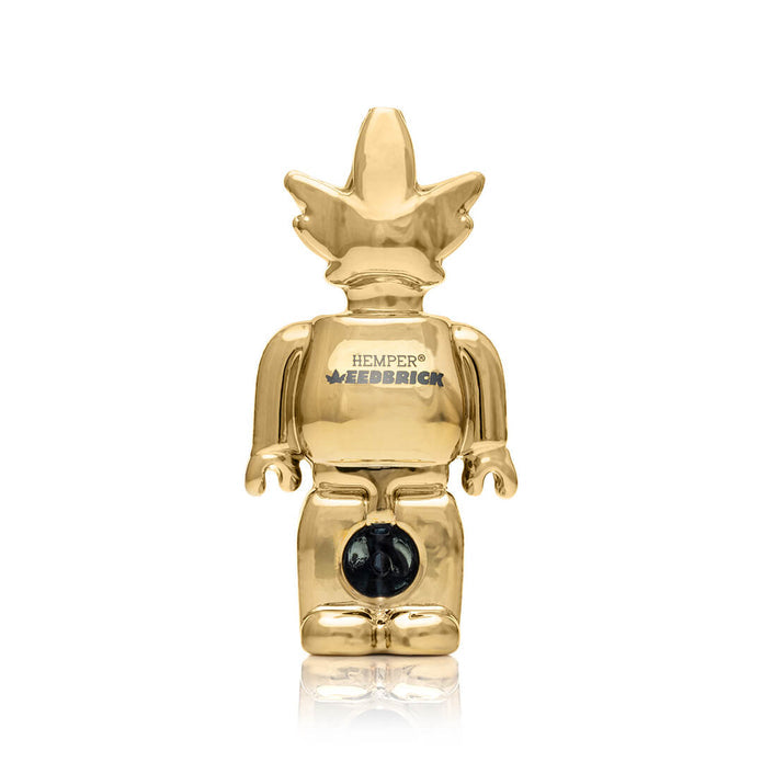 Centered front shot of gold Weedbrick glass hand pipe showing block-figure silhouette and glossy mirror finish