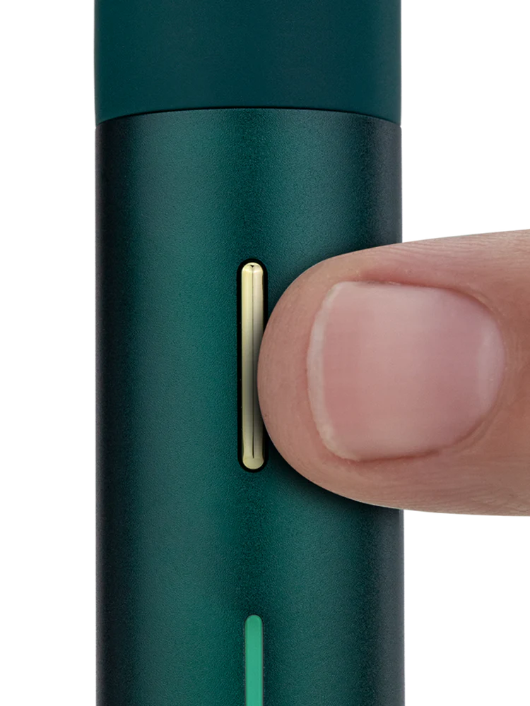 Close view of Puffco Pivot Pine showing the slim gold control button and LED bar for visual timing on the pen body.