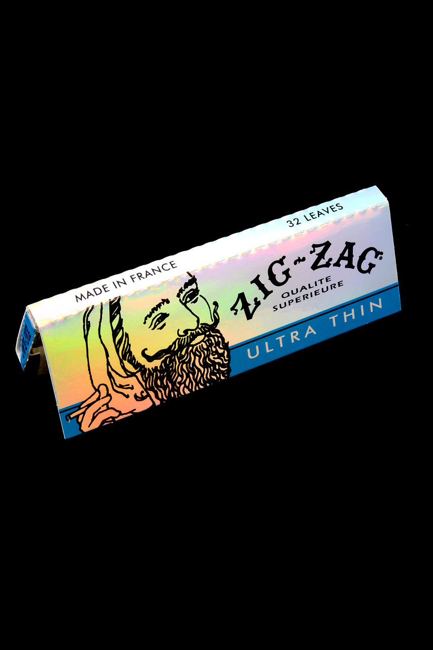 Holographic silver Zig-Zag Ultra Thin 1¼ booklet angled on black background; 32-leaf pack with natural gum.