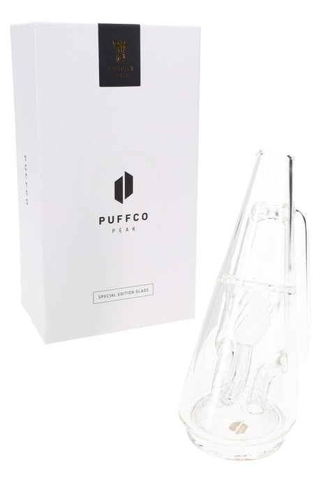 Clear Puffco Peak Ryan Fitt Recycler Glass attachment beside special edition box, showing internal recycler channels and handle.