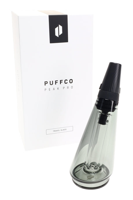 Puffco Peak Pro colored travel glass beside retail box, smoke-gray tint with sealed mouthpiece designed for spill-resistant transport.