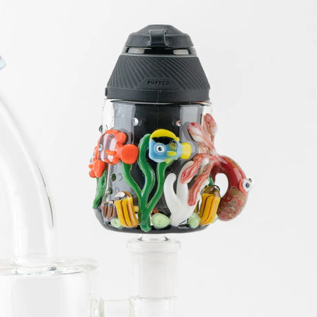 Puffco Proxy installed in the Under the Sea attachment on a glass rig, showcasing the colorful reef design and snug fit.