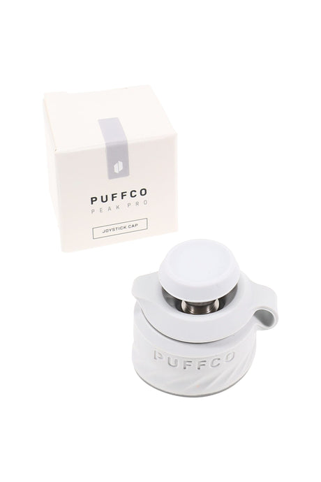 Puffco Peak Pro Joystick Cap in pearl white beside the box, silicone directional cap for the Peak Pro with joystick airflow control.