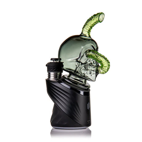 MJ Arsenal “Grim Ripper” skull glass attachment installed on a Puffco Peak base, showing full side profile and green mouthpiece.