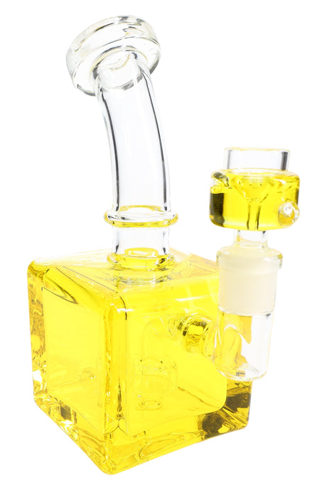Yellow fluid-filled cube bong close-up with square chamber, curved neck, and glass bowl attachment.