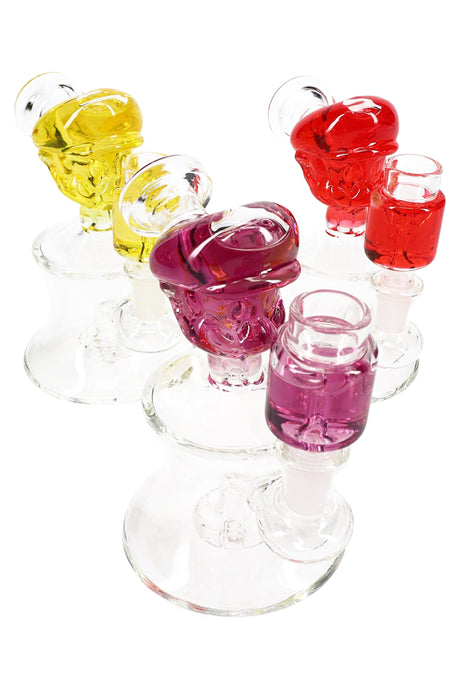 Small 5.5″ glass bong with fluid-filled plumber head and showerhead perc, clear base and purple accent chamber in front.