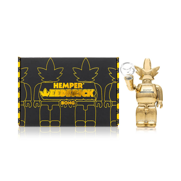 Hemper Weedbrick retail box next to mirror-gold character glass bong, shelf-ready packaging and compact footprint
