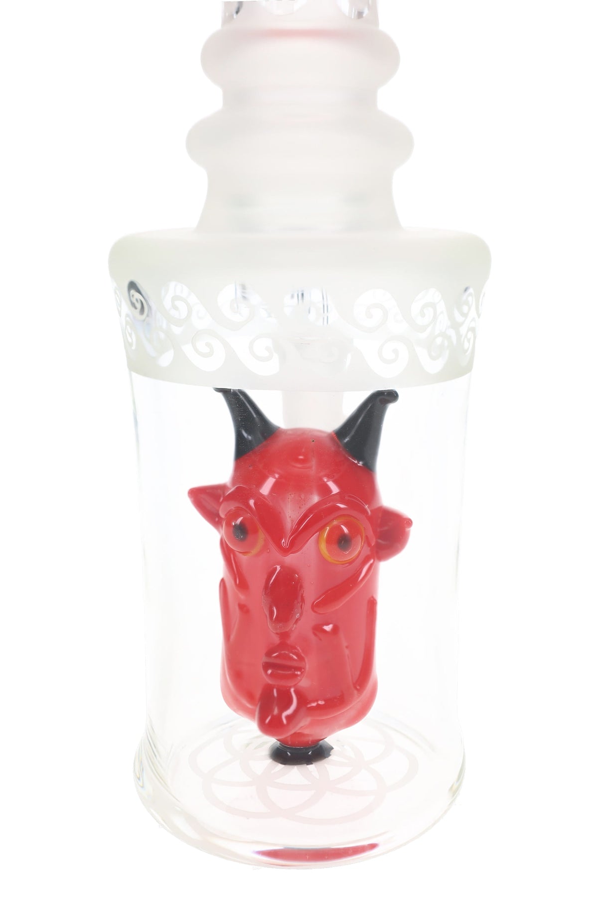 Close-up of a red demon-head perc with black horns, orange eyes and pointed ears inside a clear glass chamber.