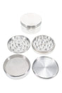 Large 4-part metal herb grinder with magnetic lid and textured grip, showing grind chamber, mesh screen, and kief catch.
