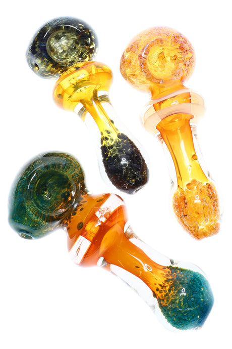 4½-inch gold-fumed color-changing glass spoon with orb bowl, maria ring, and frit accents at the tip, shown in assorted colors.