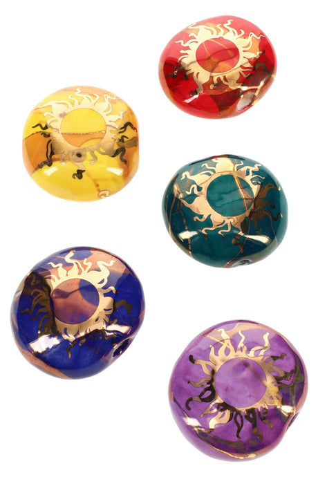 Round 2-inch ceramic smoke stones with gold sun motif in multiple colors, compact hand pipe style.