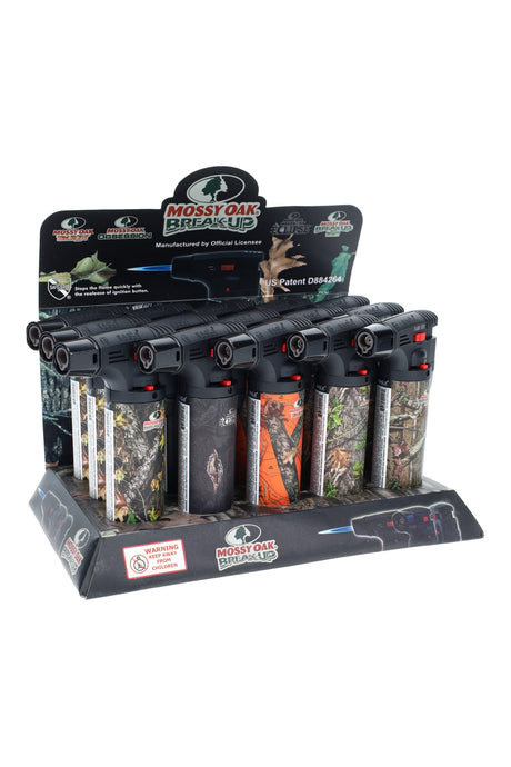 15-piece counter display of Eagle gun-style torch lighters in Mossy Oak camo with red flame-lock switches and jet nozzles, Safe-Stop branding visible.