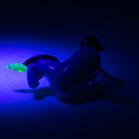 Unicorn glass bowl under blacklight with glowing UV-reactive horn attached to 14.5 mm male ground-glass joint.