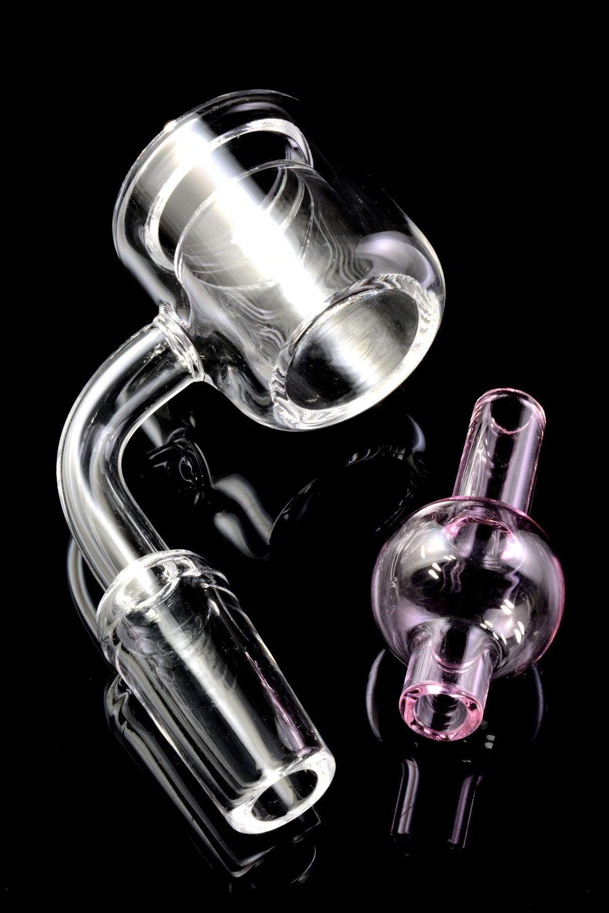 Close-up of quartz thermal bucket banger with 90° bend and pink bubble carb cap placed beside it on black.