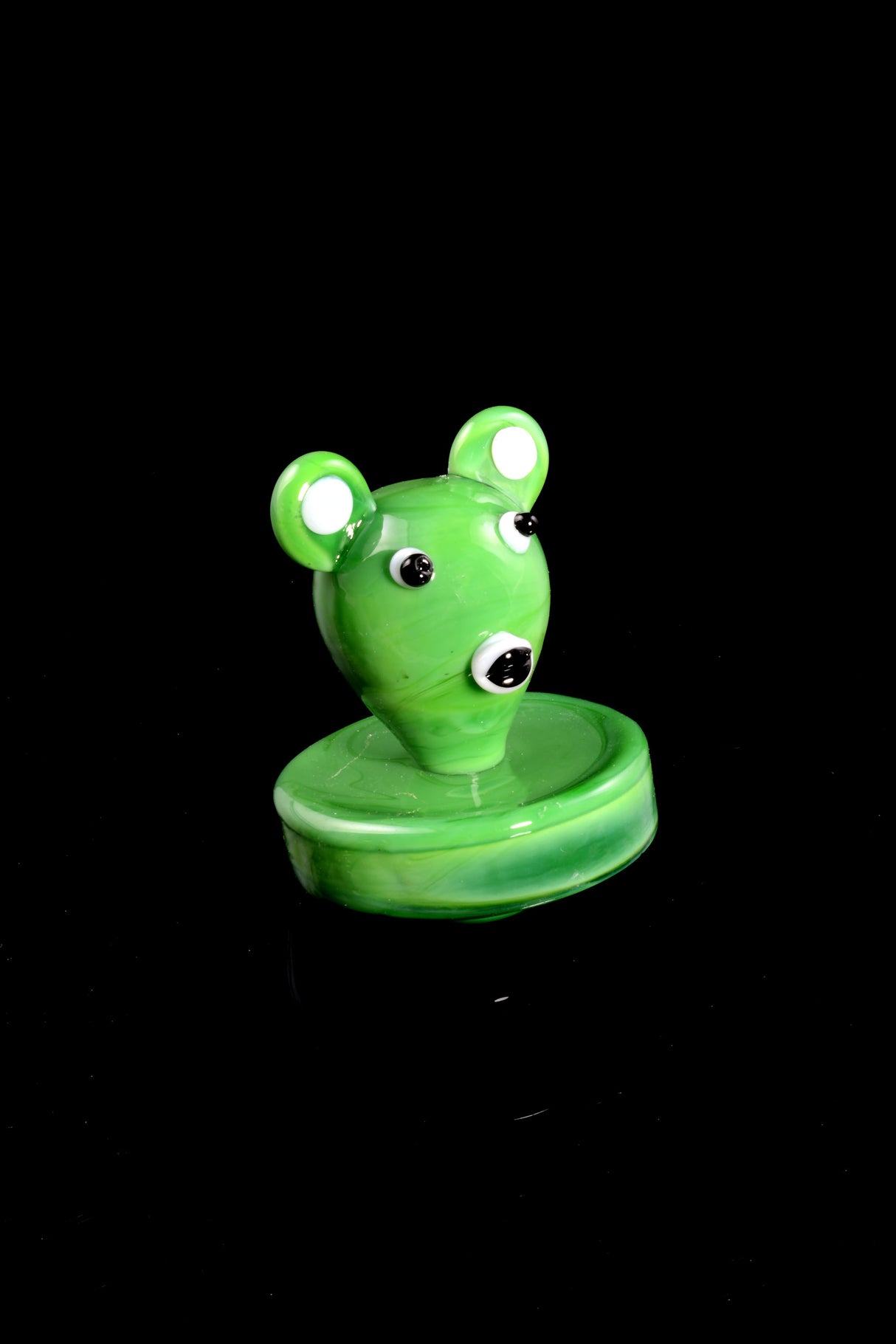 Green koala bear glass carb cap with glossy finish and wide rim, designed to cover a flat-top banger for smoother draws.
