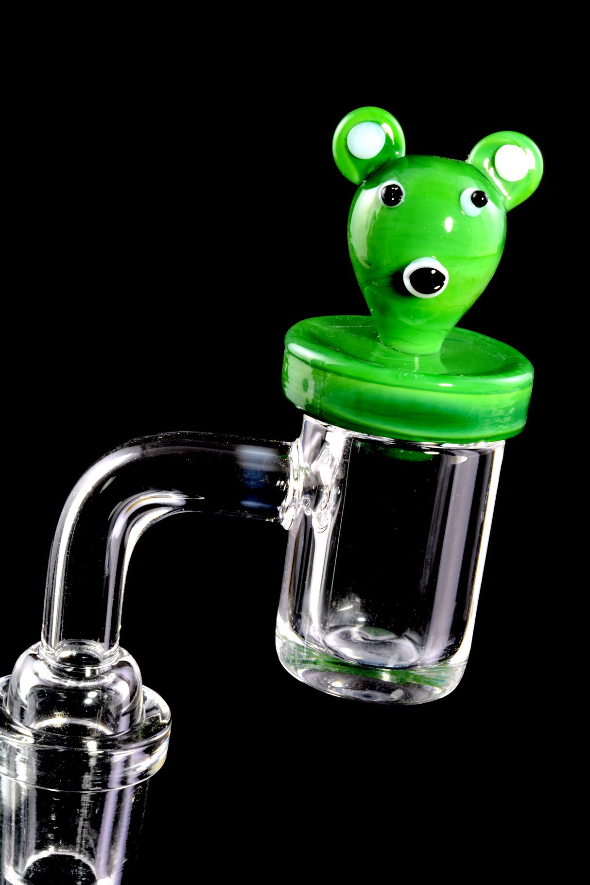 Green koala glass carb cap seated on a flat-top quartz banger, demonstrating a tight seal to retain heat and improve flavor.