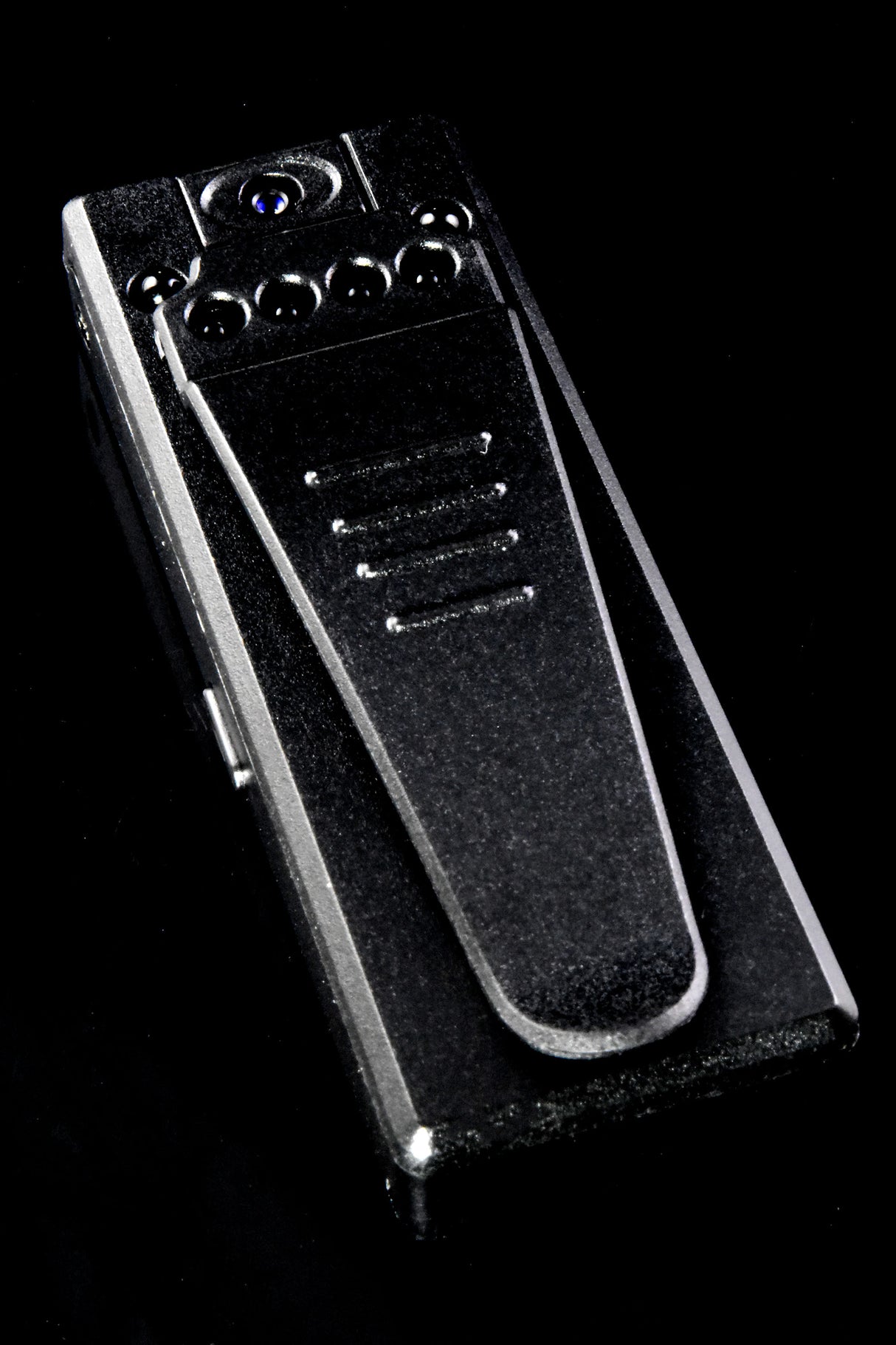 Rear view of mini HD recorder with spring metal clip, six infrared LEDs, and hidden lens on black backdrop