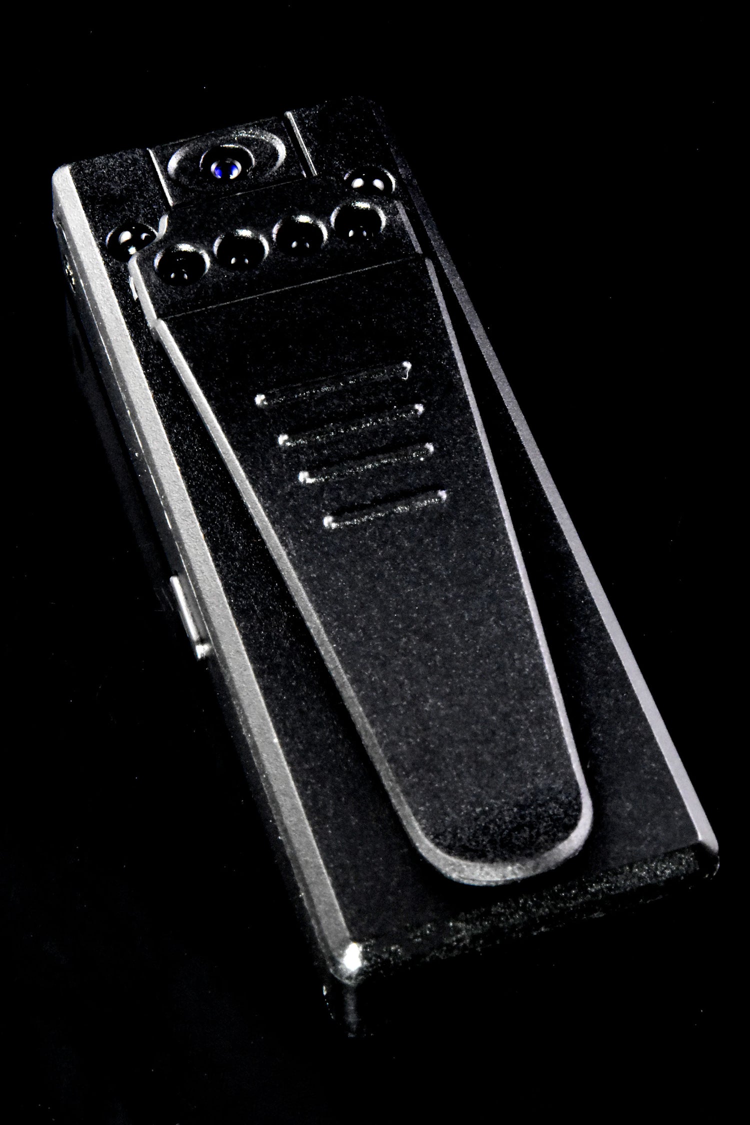 Rear view of mini HD recorder with spring metal clip, six infrared LEDs, and hidden lens on black backdrop