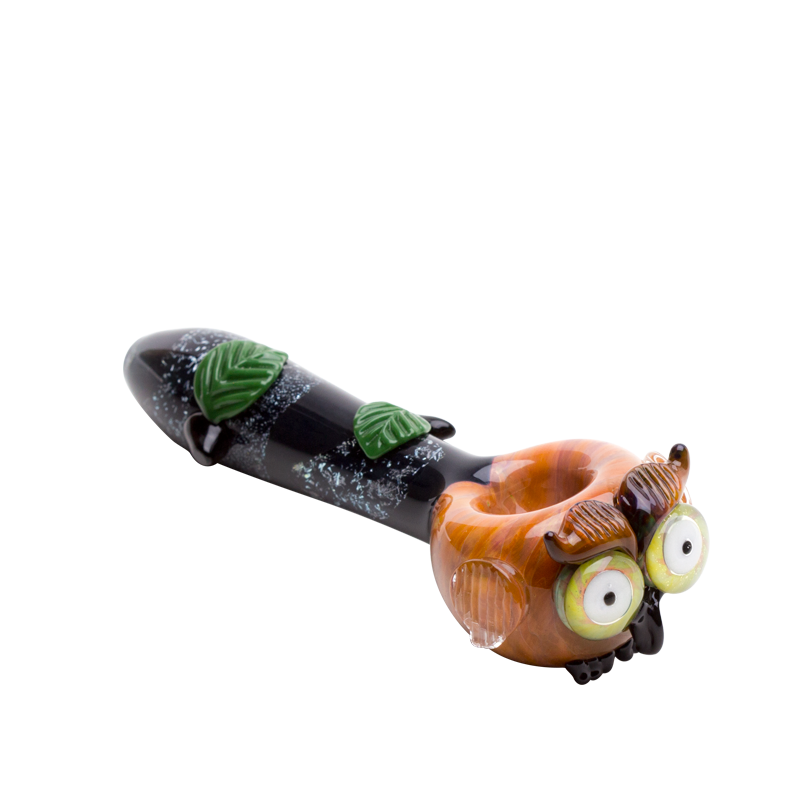 Three-quarter owl glass hand pipe with glossy amber face, raised wings, dark stem, and leafy details