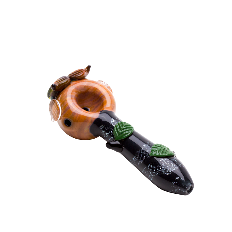 Top view of amber owl dry herb pipe with rounded bowl, green leaves, and dark branch-inspired handle
