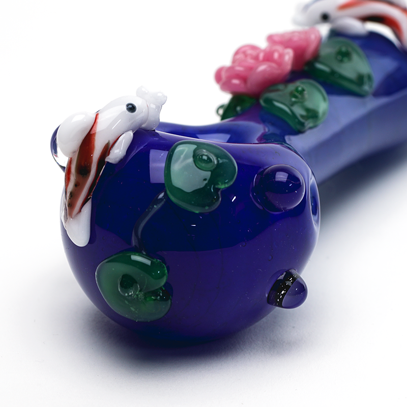 Close-up of koi pond hand pipe bowl with white-and-red fish, green lily pads, and pink blossom details