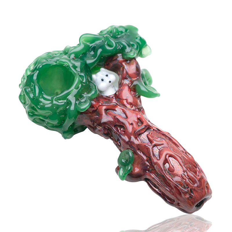 Tree-trunk spoon hand pipe with sculpted leaves, deep green bowl, and squirrel peeking from the nest
