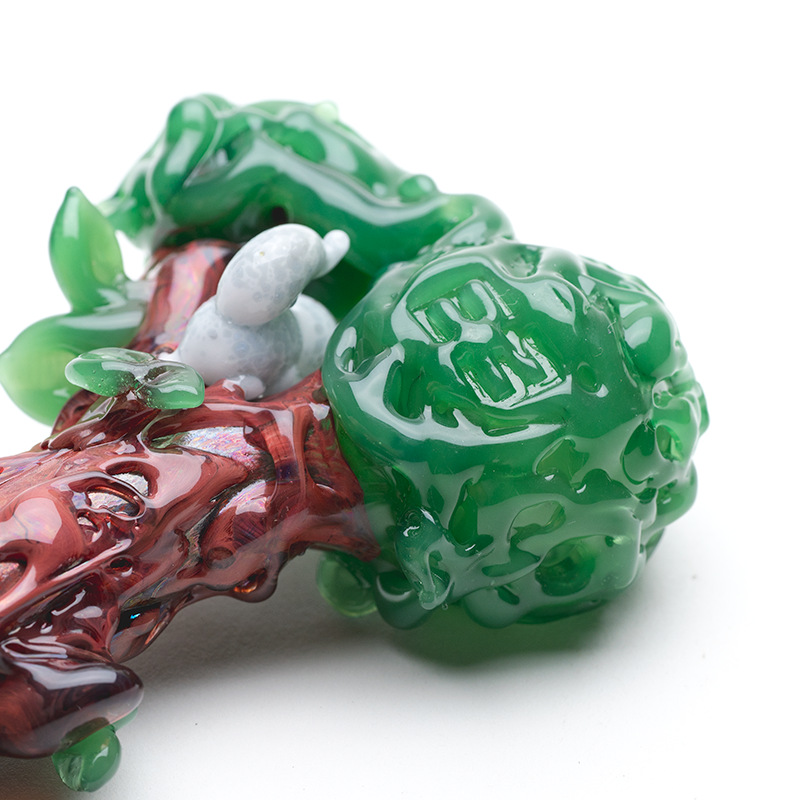 Front view of 4″ glass hand pipe with green bowl, raised leaves, and woodland tree-trunk design